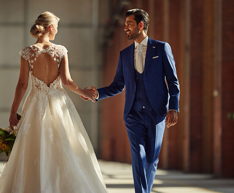 Tanzendes Hochzeitspaar. Bräutigam trägt einen royalblauen Hochzeitsanzug.