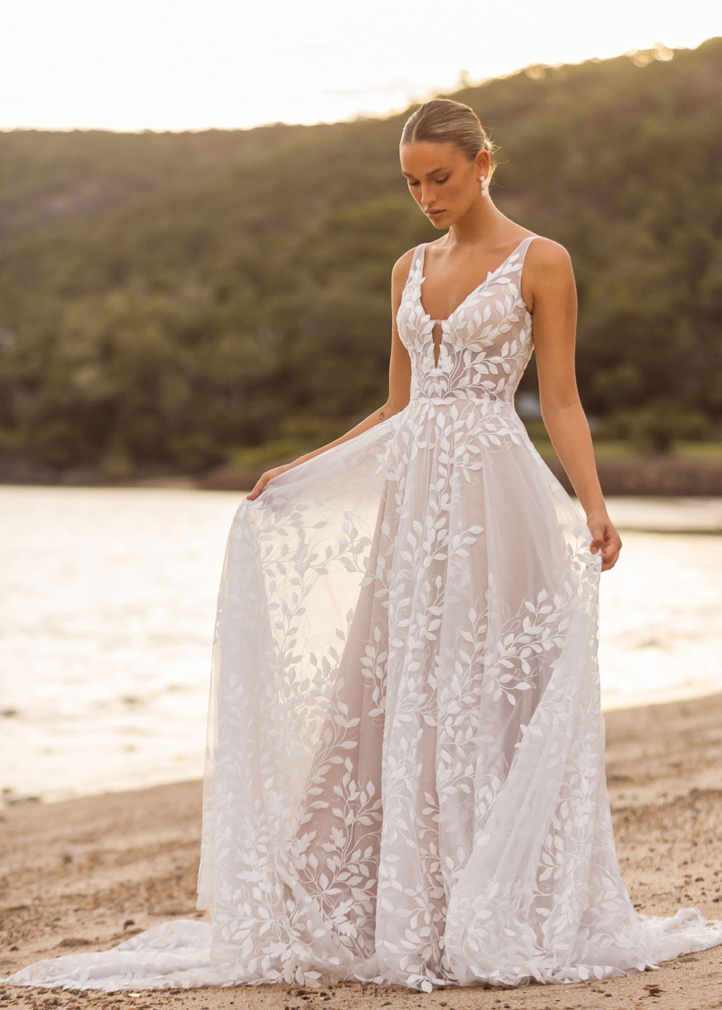 Brautkleid in A-Linie und kleiner Schleppe mit floralen Spitzen Details und luftigen Rock.
