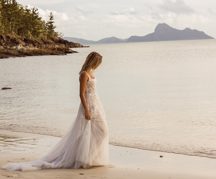 Braut am Meer trägt wunderschönes Brautkleid Jayce von Madi Lane.